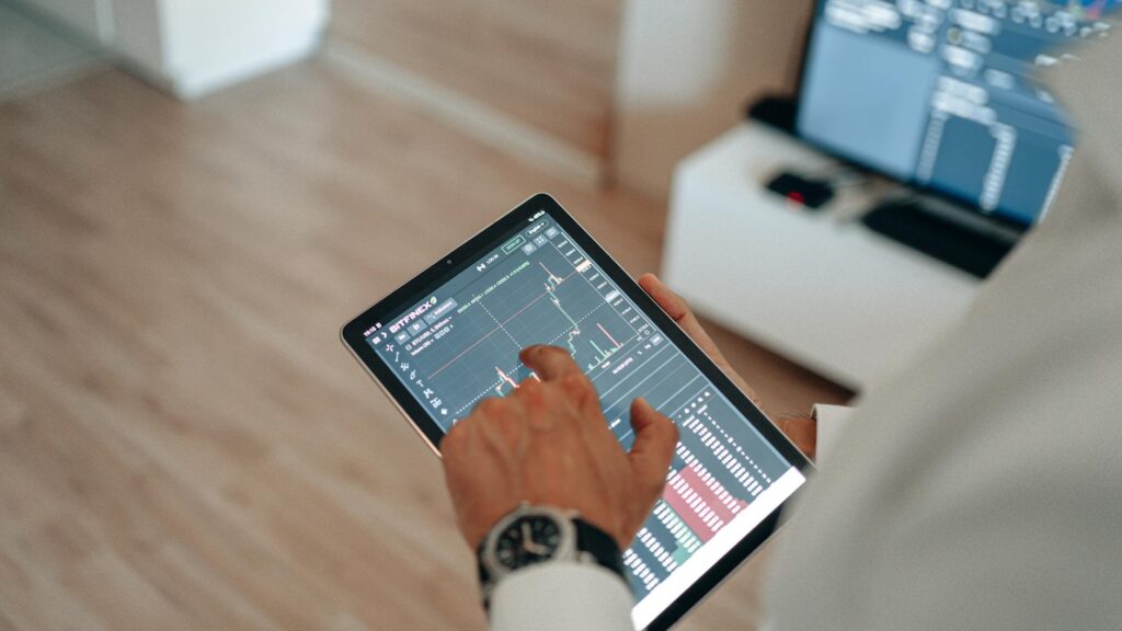 finger touching tablet screen with graph